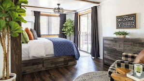 A bedroom with a bed, a dresser, a plant, and a sign indicating the location. - Arcade Cabin with Forest Views & Hot Tub (Munds Park)