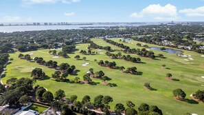 A golf course with multiple holes, water bodies, and surrounding greenery.