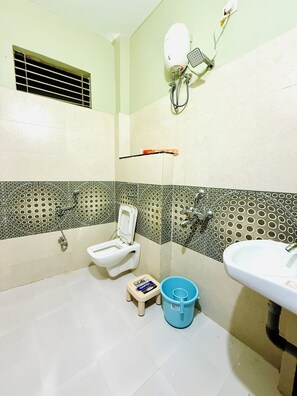 Un baño pequeño con inodoro, lavamanos y ducha.