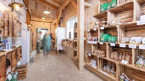 Un interior de madera con estantes llenos de diversos productos alimenticios y un refrigerador.