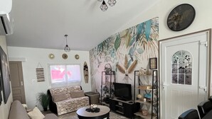 A living room with a sofa, coffee table, TV, and decorative items. - WELCOME TO "LOU PARADOU" NEW HOUSE FOR 4 PEOPLE IN PROVENCE VERTE (Méounes-lès-Montrieux)