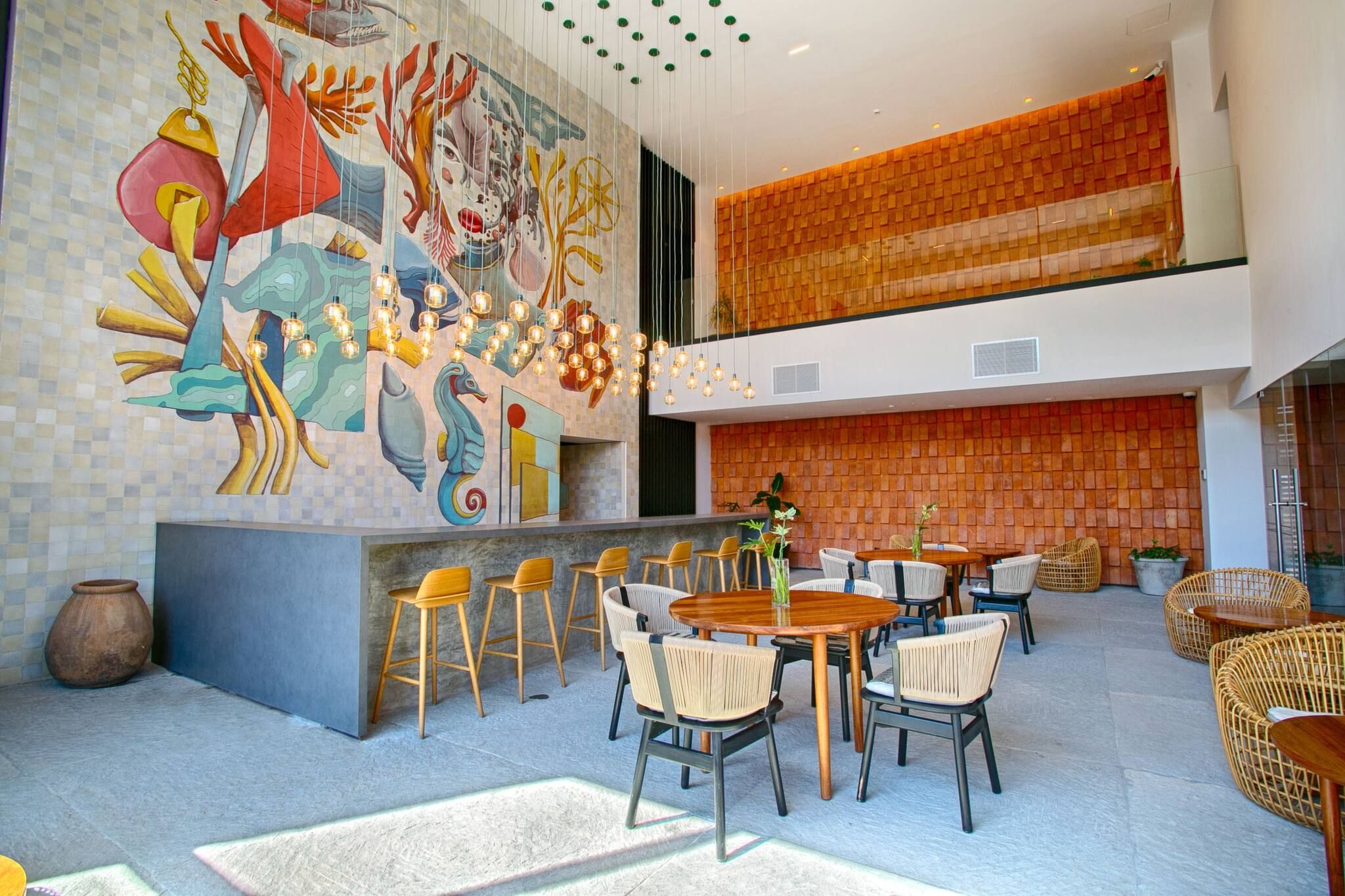Un intérieur moderne agrémenté d’une fresque murale, d’un espace salon et d’un mur en briques.
