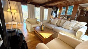 Ein gemütliches Wohnzimmer mit einem beigefarbenen Sofa, einem Holztisch und einer Lampe.
