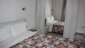 A bedroom with a bed, a nightstand, a mirror, and a wardrobe. - Tre Cuori - Amy. (Genova)