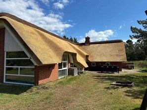 A house with a thatched roof and a brick exterior. - 4 Star Holiday Home in Blavand (Blavand)