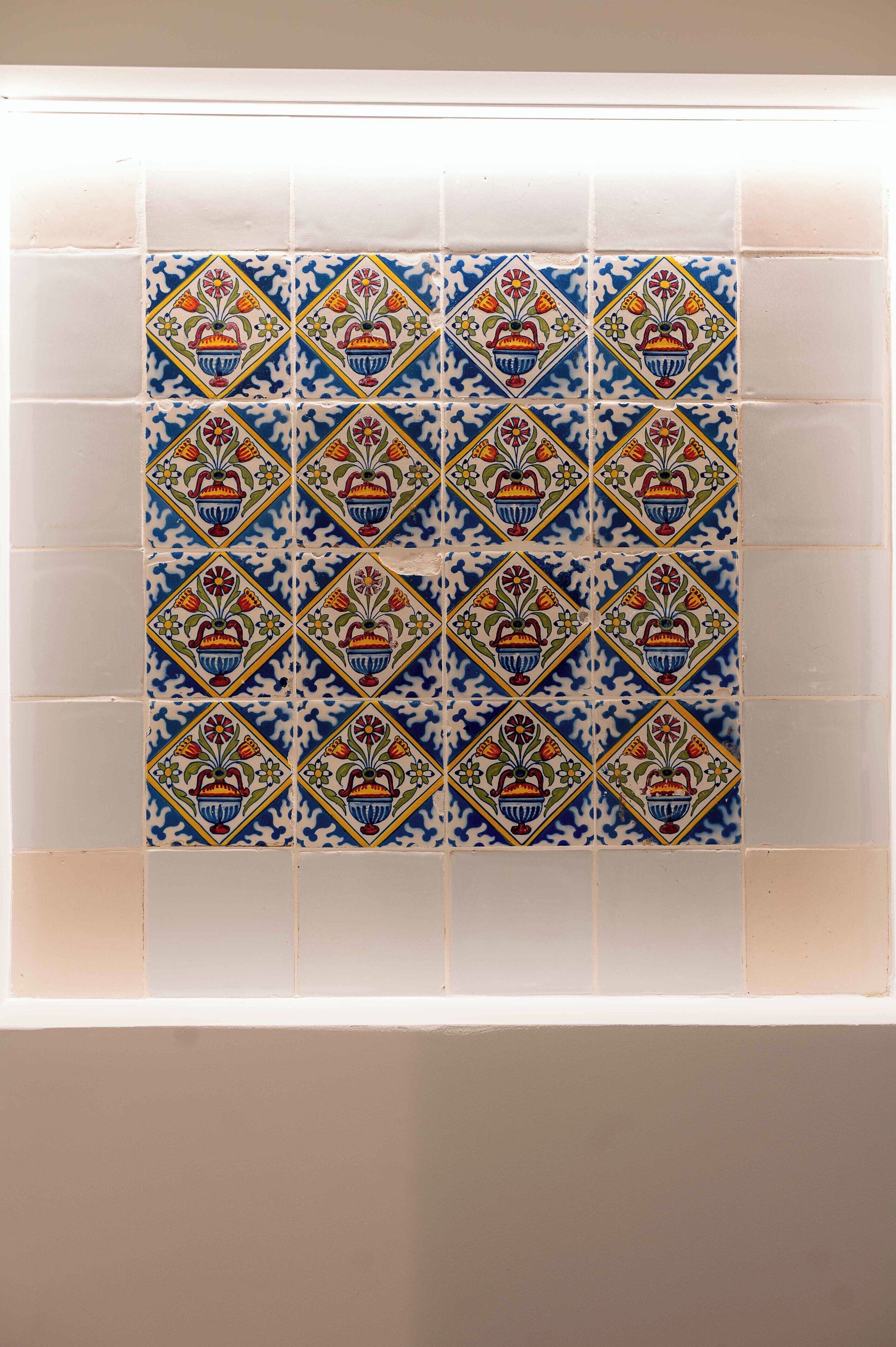 A tiled wall with a repeating pattern of blue and white tiles featuring floral designs.
