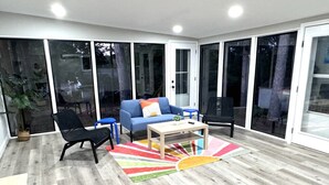 A spacious room with a blue sofa, a coffee table, and a colorful rug.