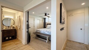Een moderne slaapkamer met een bed, nachtkastje en plafondventilator.