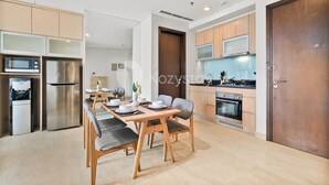 Una cocina moderna con electrodomésticos de acero inoxidable, armarios de madera y un comedor con una mesa grande y sillas.