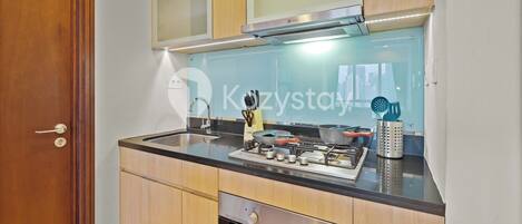 A modern kitchen with wooden cabinets, a stainless steel range, and a built-in oven.