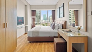 Una habitación de hotel moderna con una cama grande, un escritorio y vistas a la ciudad.
