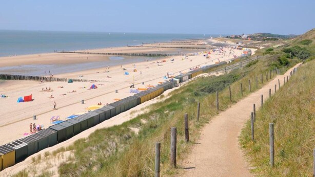 A beach with a long wooden fence, a sandy path, and tents. - Holiday Home in Zeeland Near the Beach (Biggekerke)