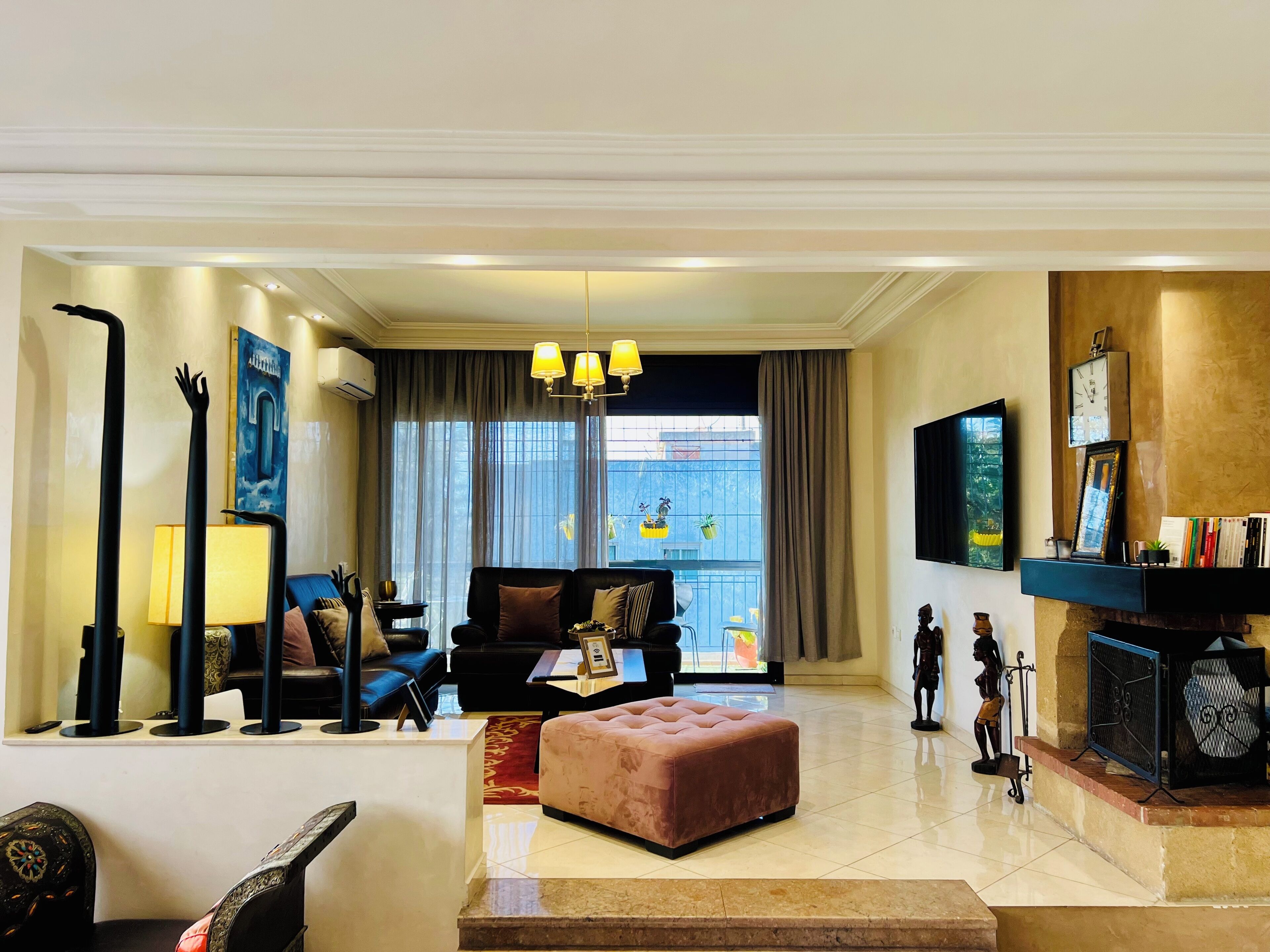 TV connectée, cheminée, livres, écrans d'ordinateur