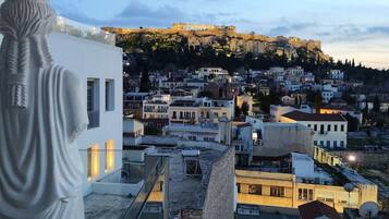 A view from a balcony overlooking a cityscape with historical buildings and a hilltop fortress.