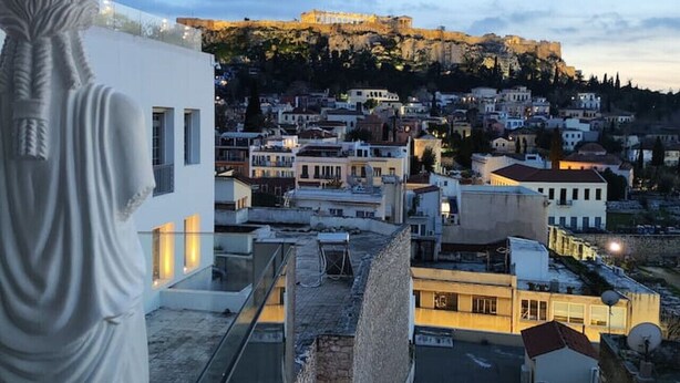 A view from a balcony overlooking a cityscape with historical buildings and a hilltop fortress. - Luxury Acropolis-View Apartment with Panoramic Terrace | Monastiraki (Athina)