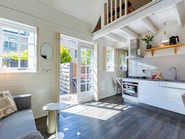 Una cocina moderna con comedor, una escalera y vistas al exterior.