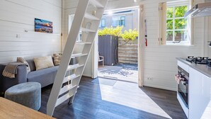 A modern interior with a staircase, a kitchen, and a living area with a sofa and a painting. - Holiday Home in Domburg Near the Beach (Domburg)
