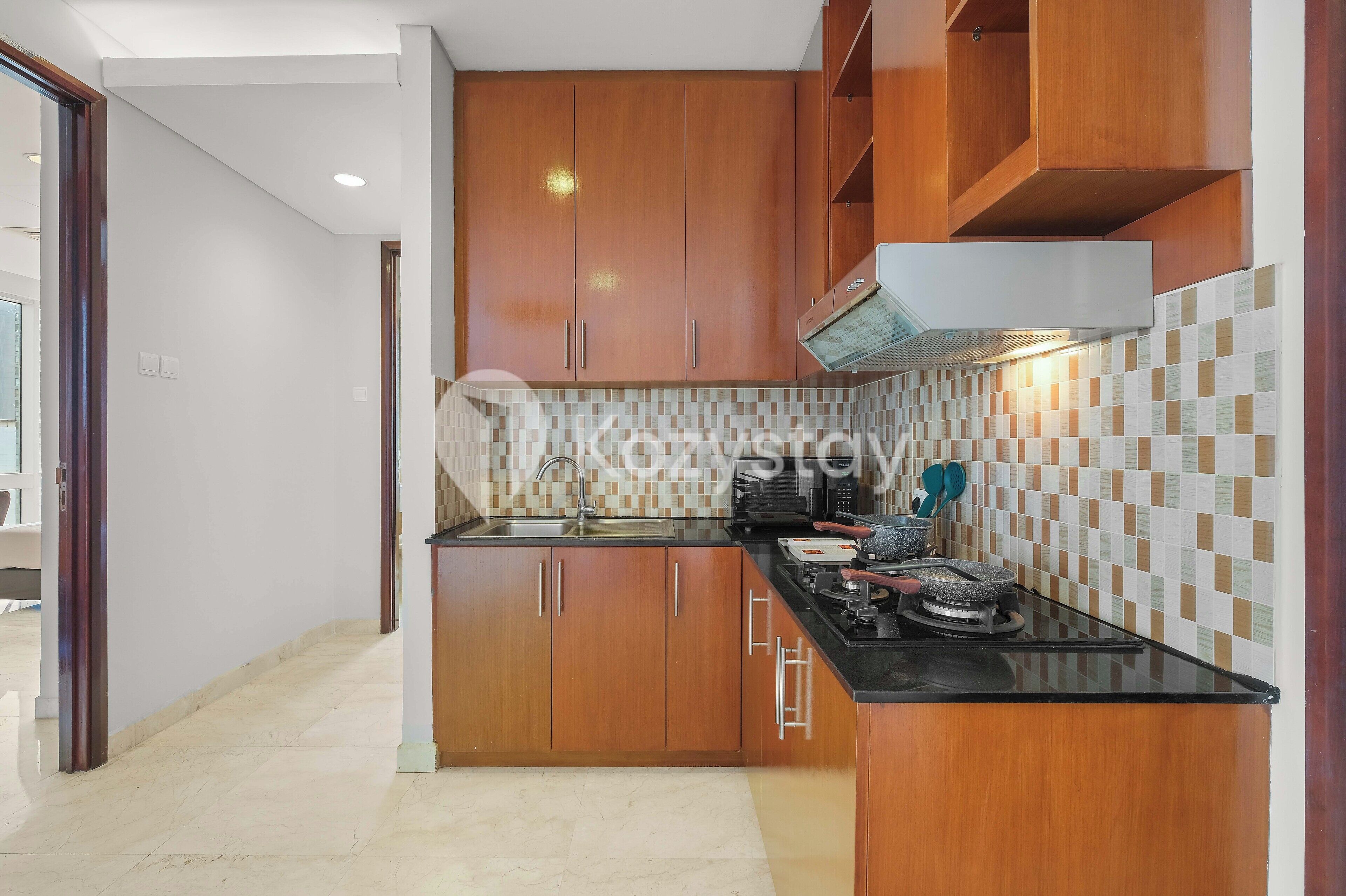 A modern kitchen with wooden cabinets, a black countertop, and a tiled backsplash.