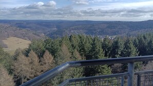 Et panorama over et bjergrigt landskab med en by i dalen nedenfor.