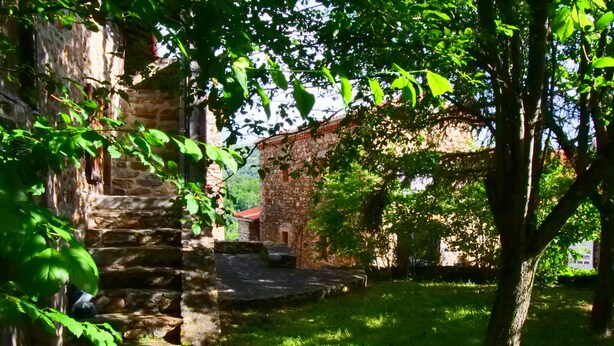 A stone building with a red roof, surrounded by lush greenery and a stone staircase leading up to a door. - House "Les sauvages" - Nature and charm on the banks of the Allier 8 to 10 people (Blassac)