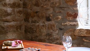 A rustic wooden table with a plate, a wine glass, and a cheese board with various cheeses and a knife. - House "Les sauvages" - Nature and charm on the banks of the Allier 8 to 10 people (Blassac)