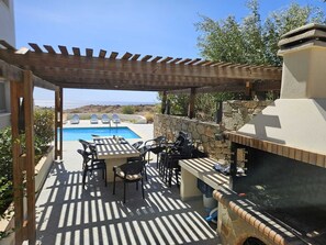 Outdoor dining - 5-bedroom villa with heated pool, sea and mountain views, 5 minutes from the center of town (Makry Gialos)