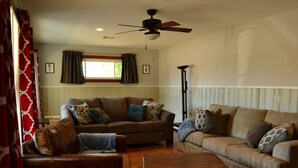 Ein Wohnzimmer mit zwei Sofas, einem Couchtisch und einem Deckenventilator.