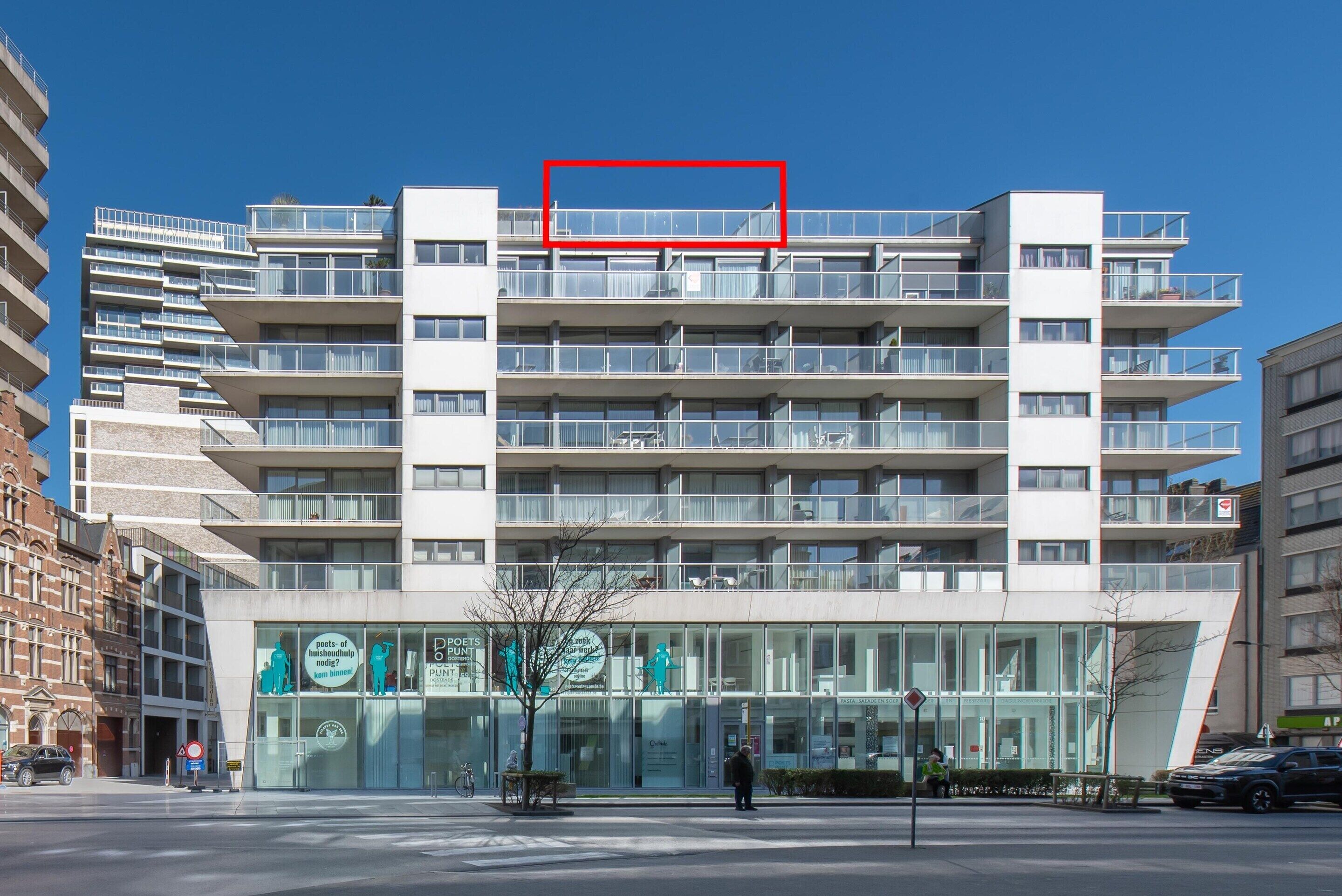 A modern multi-story building with a glass facade, multiple balconies, and a sign indicating it is a poets' hostel.