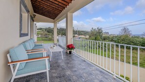 A covered outdoor seating area with a view of the landscape.