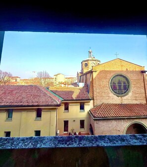 Una iglesia con una torre del reloj y un ventanal redondo.