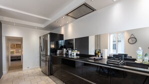 Eine moderne Küche mit einem eingebauten Kühlschrank, einer Kaffeemaschine und einem großen Fenster.