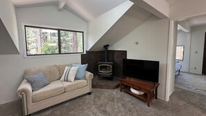 A living room with a sofa, a fireplace, and a television. - Quiet 1 Bdrm walk to beach & trails.  Close to ski areas. (Kings Beach)