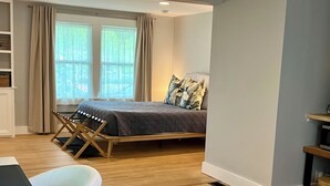 A bedroom with a bed, a desk, and a chair. - Coastal Private Guest Suite (Cohasset)