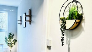 A hallway with a wall-mounted plant holder, a door, and a window. - 3-bedroom St faith street Lincoln location+comfort+FREE parking for 2 cars (Lincoln)