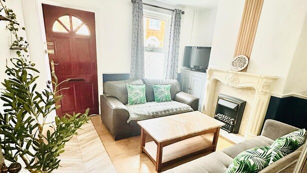 A living room with a sofa, a coffee table, a fireplace, and a TV. - 3-bedroom St faith street Lincoln location+comfort+FREE parking for 2 cars (Lincoln)