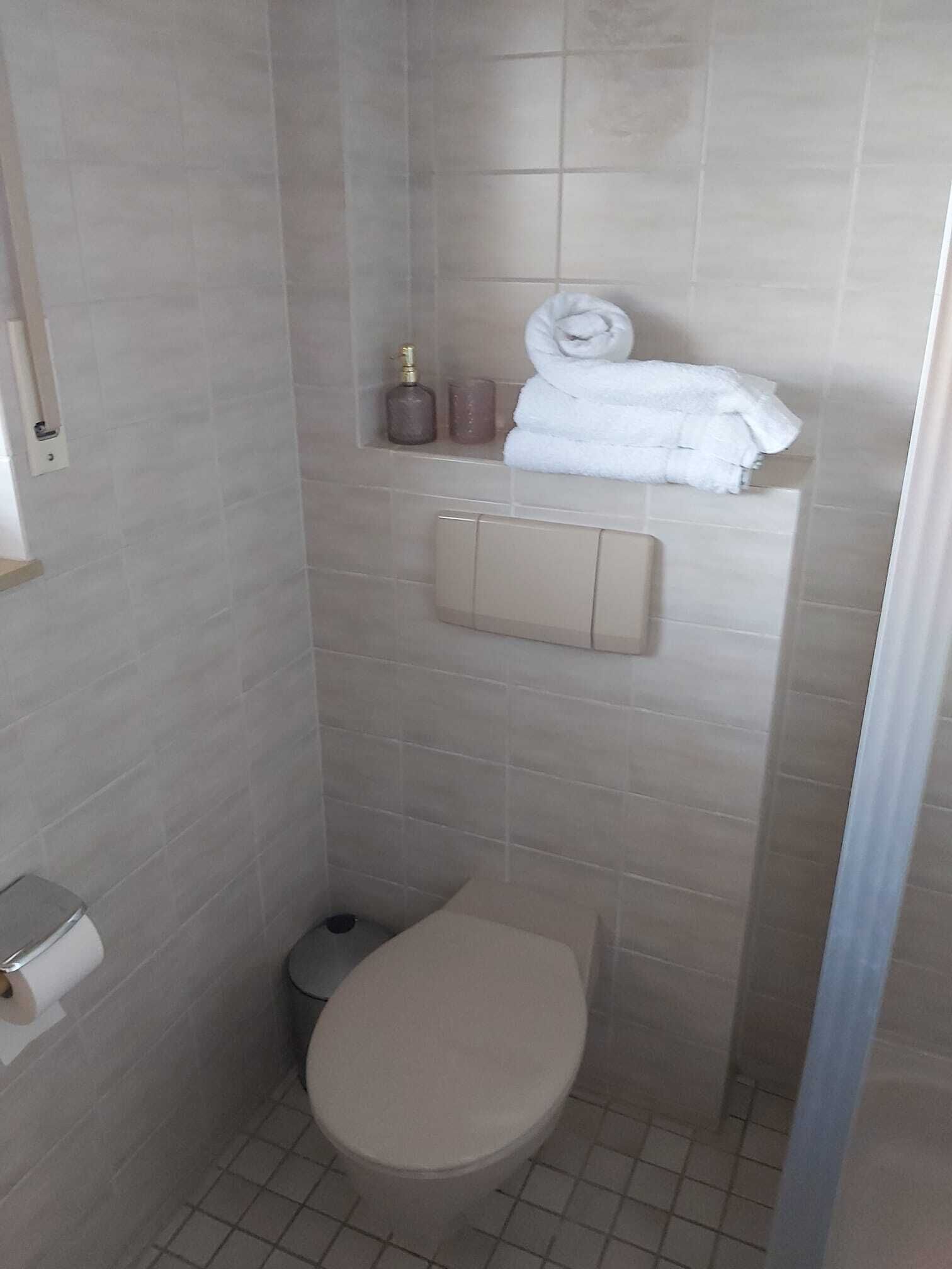 Une petite salle de bain moderne comprenant des toilettes, un lavabo et un espace douche.