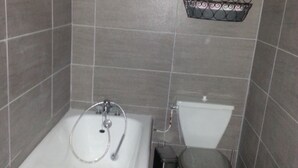 Ein Badezimmer mit Badewanne, Toilette und Dusche.