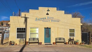 En byggnad med en skylt som visar texten ”Copper Row Guest House”.