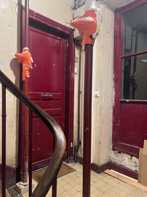 Sturdy door with a metal handle and worn wooden handrail.