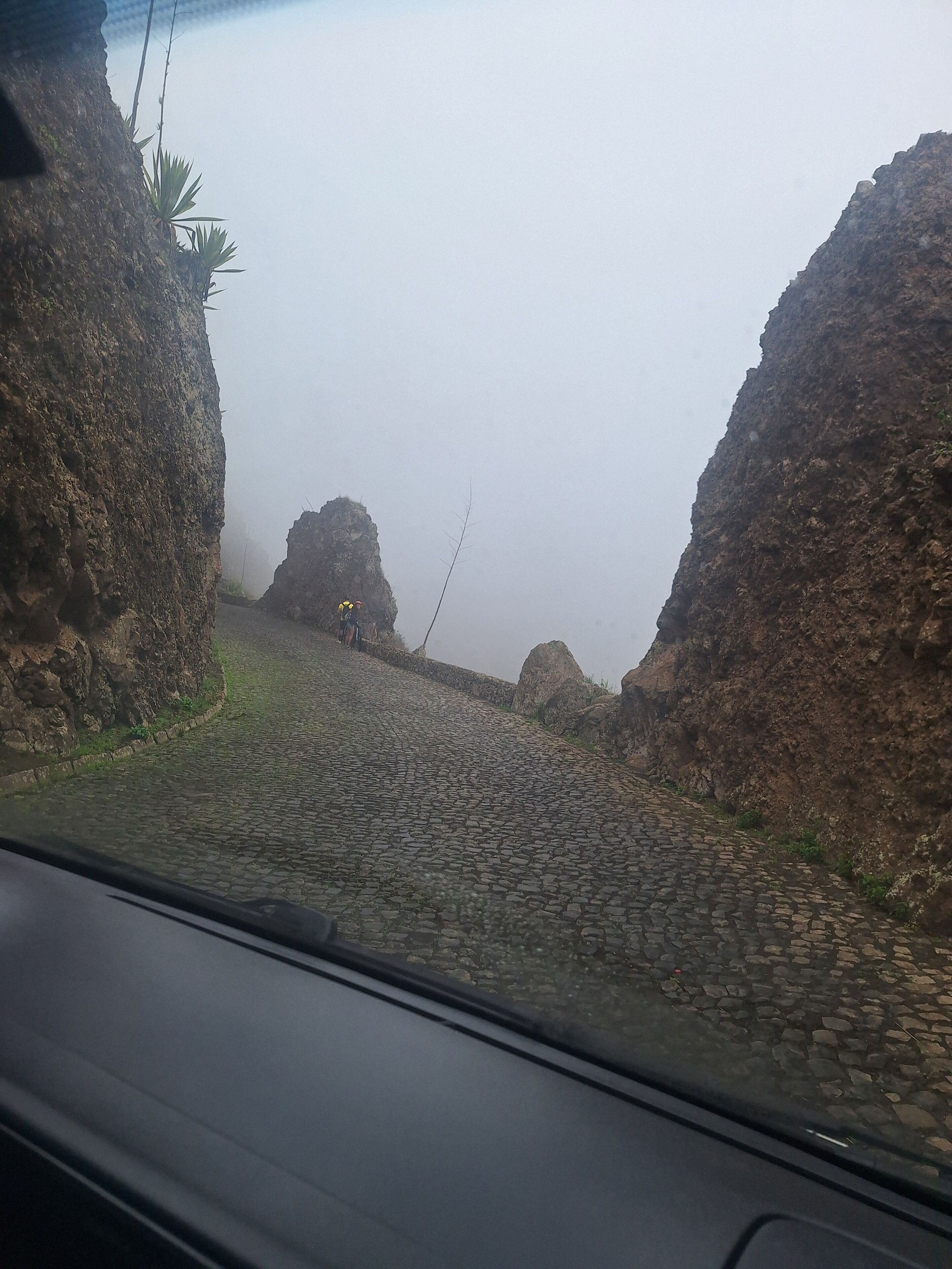 Ein Kopfsteinpflasterweg, begrenzt von steilen Felsen.