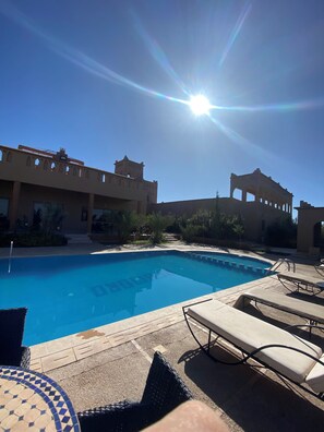 A swimming pool with lounge chairs and a clear sky. - Auberge Famille BenMoro (Skoura)