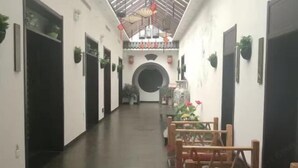 A corridor with a high ceiling, black doors, and potted plants. - Huaxia Jingdu Business Hotel (Taiyuan)