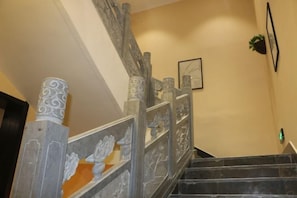 A staircase with ornate railings and a framed picture on the wall.