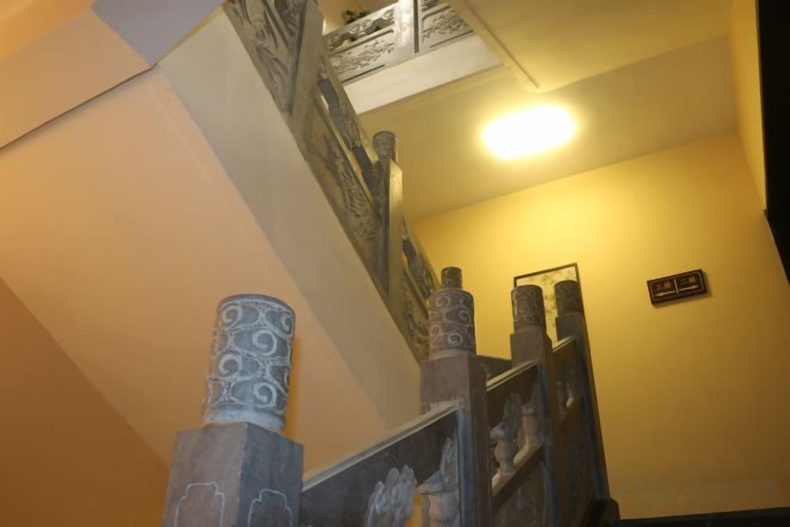A staircase with ornate balusters and a light fixture above.