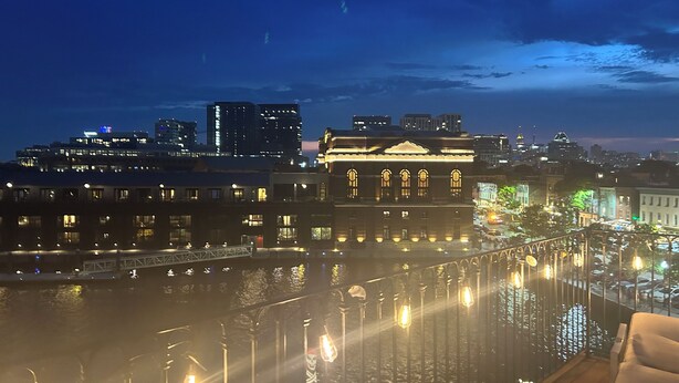 A nighttime cityscape with a prominent building featuring arched windows and a classical facade. - Step into History: Charming Fells Point Retreat (Baltimore)