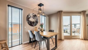 A dining area with a wooden table, grey chairs, and a globe decoration. - Spacious 120m2 Watervilla With Sauna Near Amsterdam And Schiphol. (Aalsmeer)