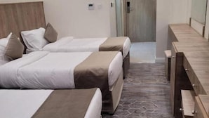 Et hotelværelse med to senge, et træhovedgærde, et skrivebord og et mønstret gulv.