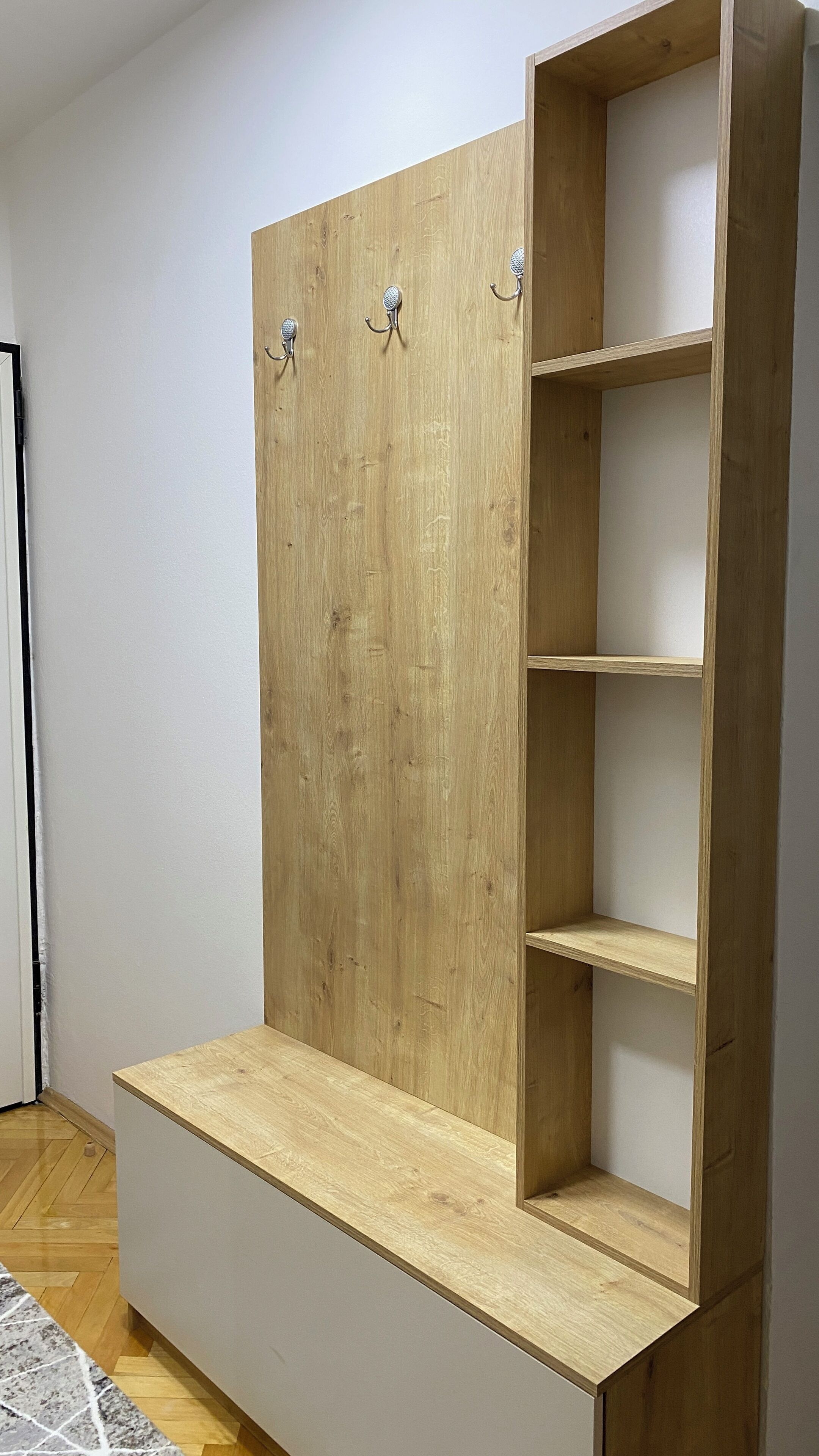 Une armoire en bois avec trois étagères et un banc.