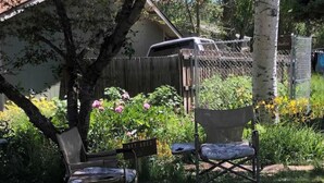 A garden with two chairs, a wooden fence, and a sign that reads "PET AREA". - Mountain Paradise - a private guest suite in Flagstaff (Flagstaff)