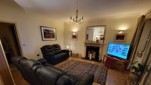 A living room with a fireplace, a television, and a large window.